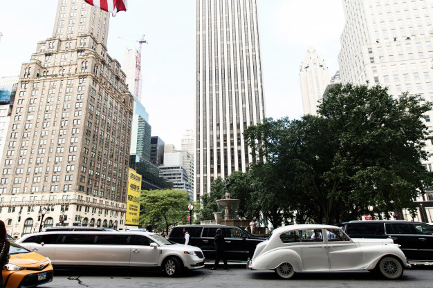 white-retro-car-and-new-limousine-ride-along-the-street-in-new-york_8353-1464